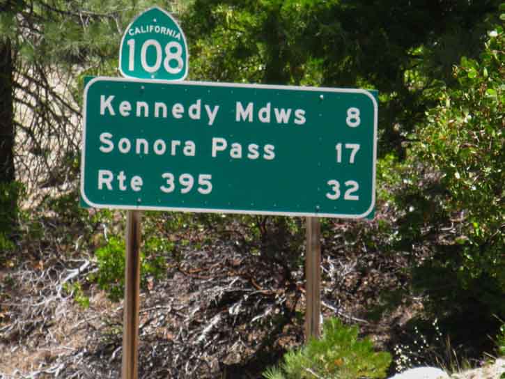 Highway 108 road sign at Clarks Fork Road with miles.