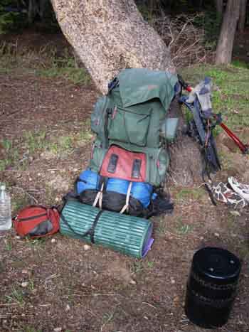 Pack as comfortable seat in backpacking campsite.