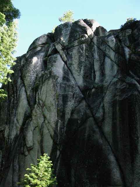 Sweet granite formations rise out of the shadow and light of the forest.