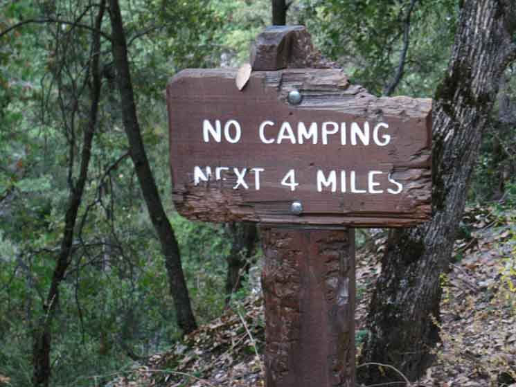 Sign marking four mile prohibition of camping from the Hetch Hetchy Trailhead.