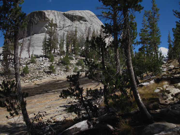 Vast granite block rises above Emeric Lake, dividing it from our trail.