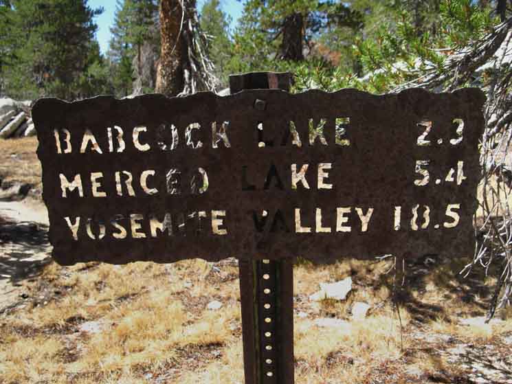 Sign specifying miles to Merced Lake and Yosemite Valley from the Emeric Lake trail junction.
